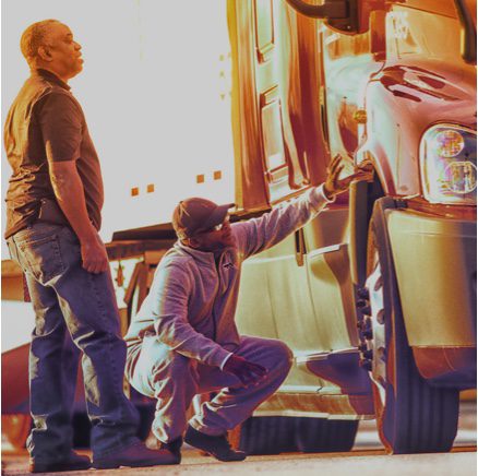 Drivers looking at a truck wheel