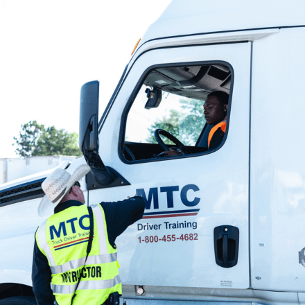 CDL instructor and student in cab of truck