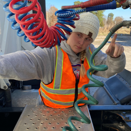 Young woman doing a pre-trip inspection during CDL training